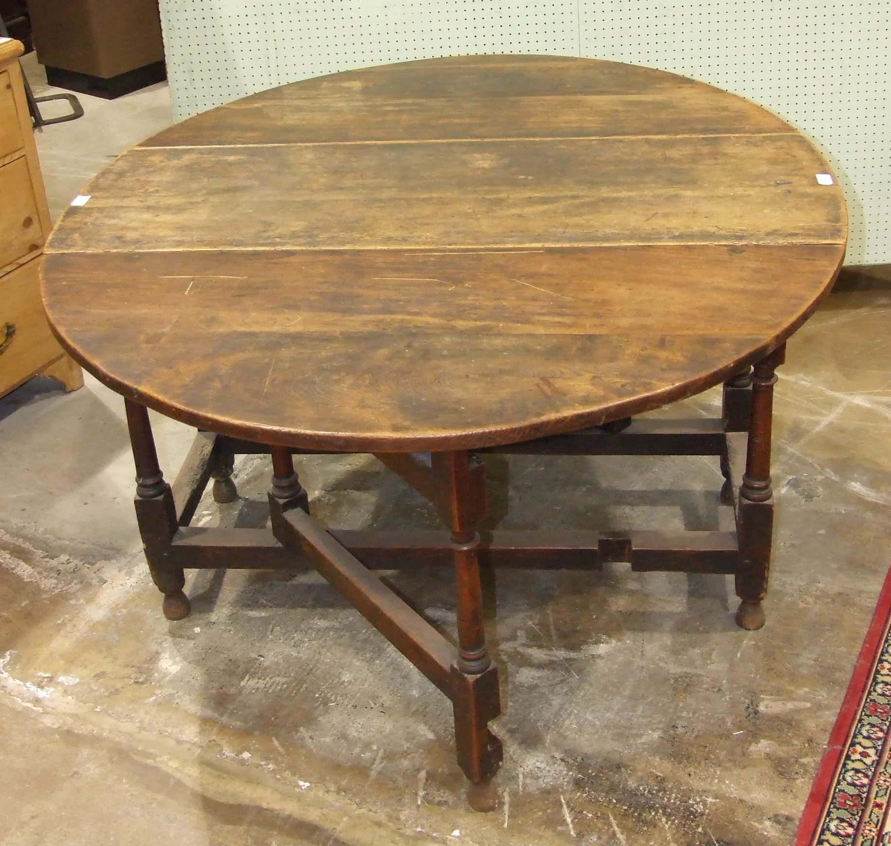 An antique oak gate-leg drop-leaf table with fitted end drawer, on turned legs, 146.5 x 120cm.