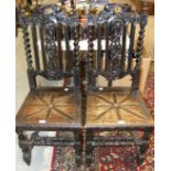A pair of oak hall chairs, each with carved centre splat, barley-twist supports and solid seat and a
