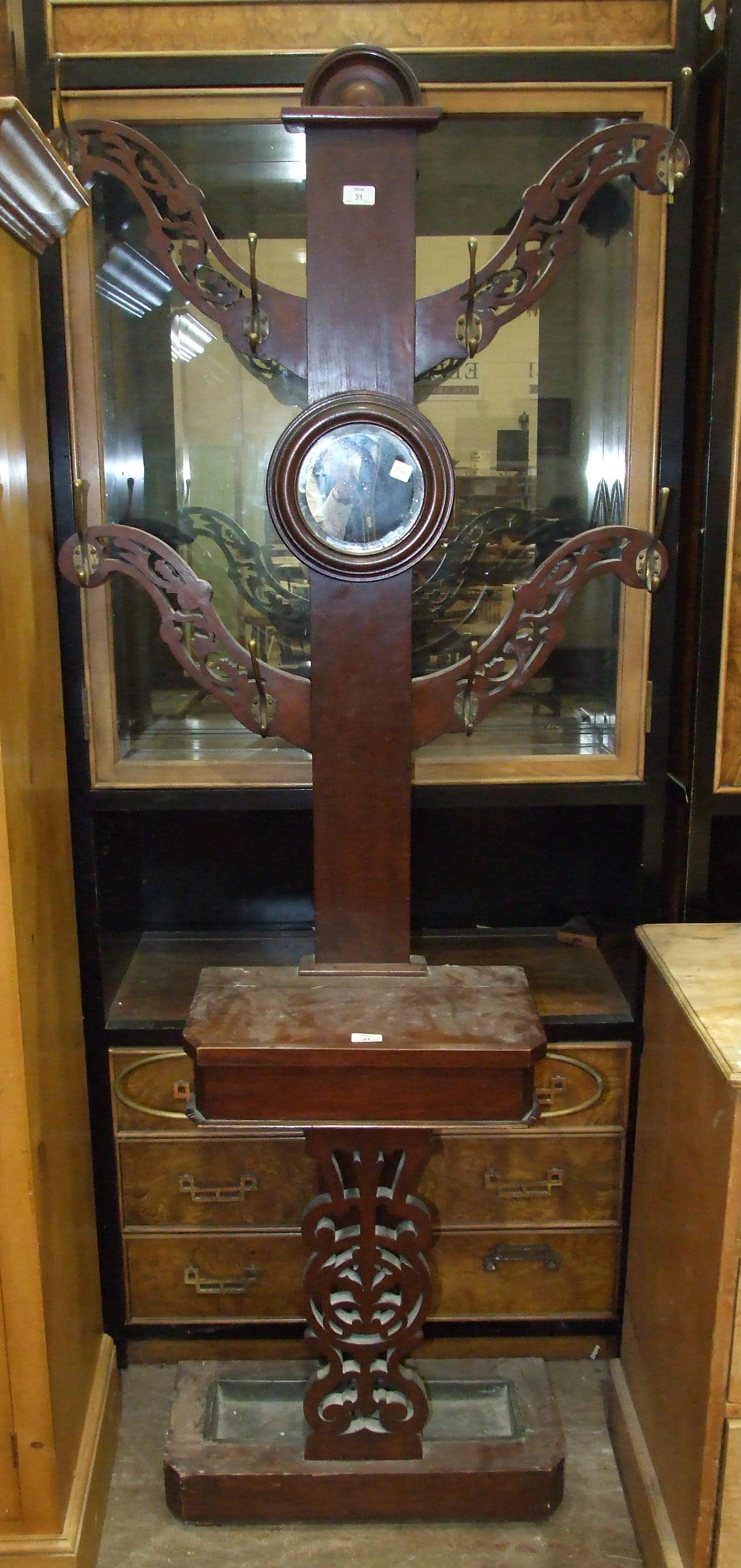 A Late-Victorian stained mahogany four-branch hall stand with central circular mirror, glove box and