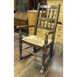 A child's stained wood rush-seated rocking chair, an oak hall stand and a small green-painted set of