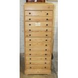 A pine narrow chest of twelve drawers, 45.5cm wide, 123cm high.