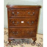 A 'Jaycee' low walnut bedside chest, the hinged rectangular fold-over top above three drawers, on