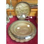 Three Middle Eastern embossed copper bowls, approximately 26cm diameter, a European copper bowl