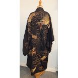 A 20th century Japanese black silk kimono decorated with dragons embroidered in gold and coloured