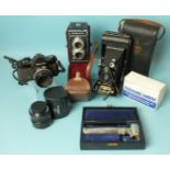 A Nikon Nikkormat 35mm camera with Nikkor 50mm 1:2 lens, a Kodak 3 Series III folding camera, a