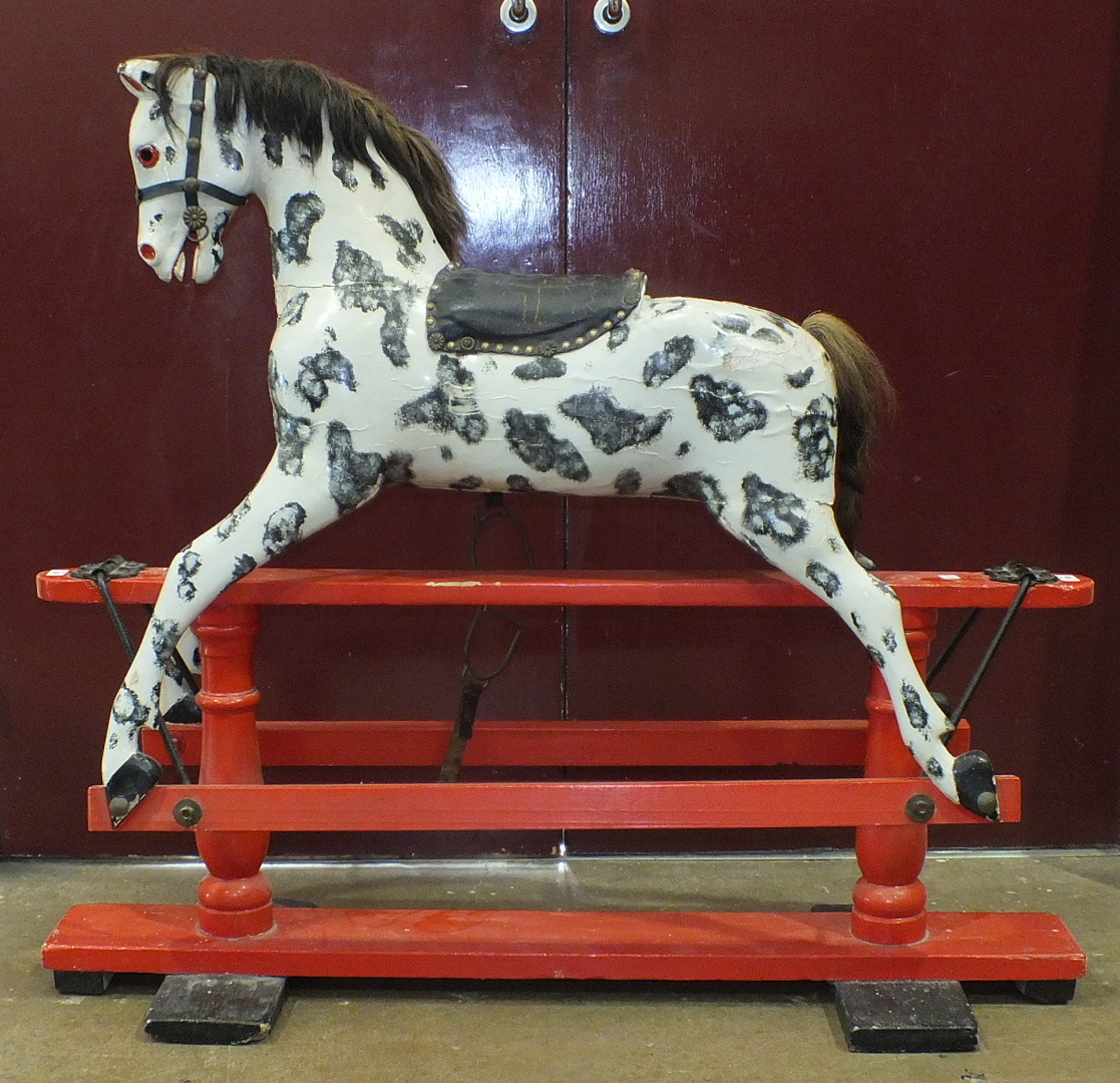 A Victorian rocking horse mounted on trestle base, repainted, with mane, tail, saddle and harness,