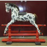 A Victorian rocking horse mounted on trestle base, repainted, with mane, tail, saddle and harness,