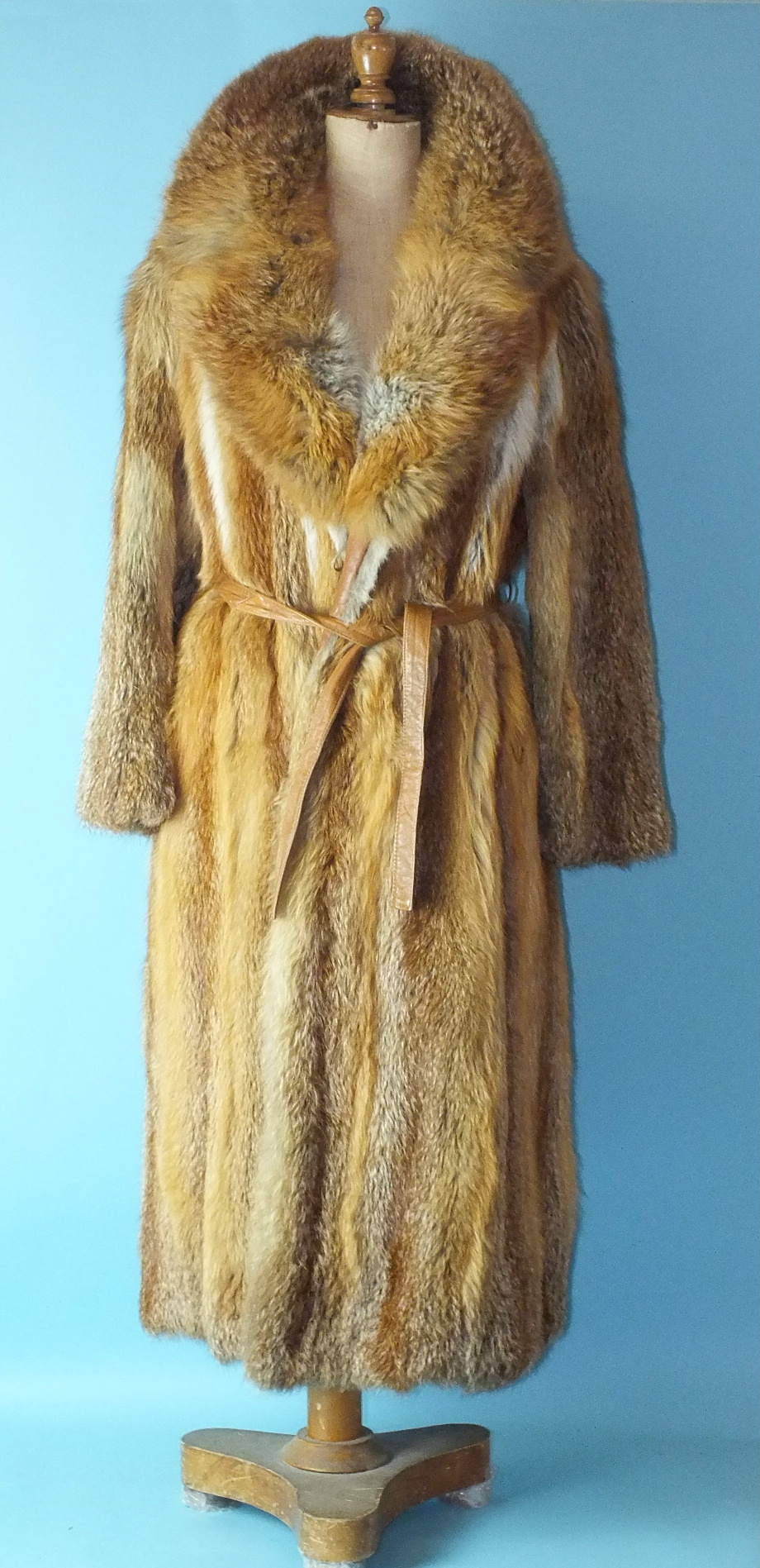 A full-length fur coat with leather belt, possibly fox.