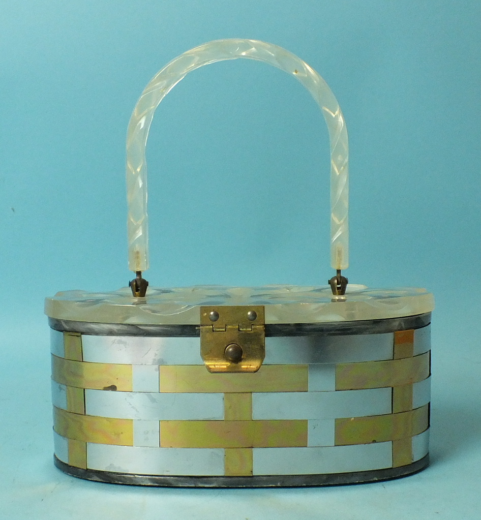 A 1950's woven metal handbag of oval shape with incised clear Lucite lid and handle, 21cm long.