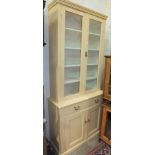 A late-19th/early-20th century painted pine bookcase, the upper section fitted with a pair of glazed
