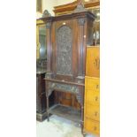 A Continental carved oak side cupboard having a single carved door above a drawer, on turned legs,