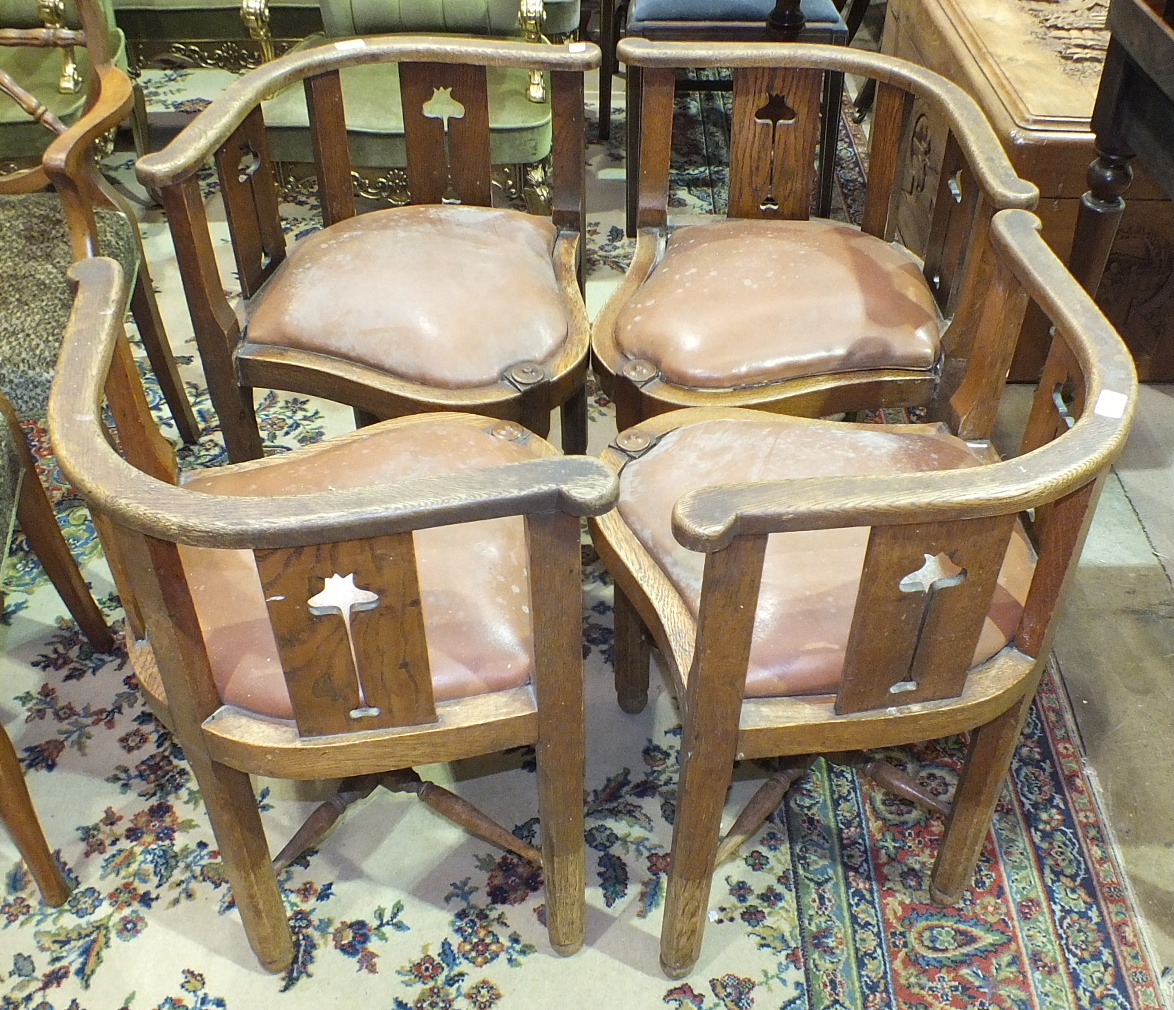 A set of four Edwardian oak corner chairs with low bowed backs, pierced Art Nouveau-style floral