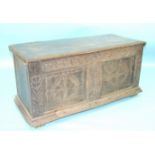 An antique oak coffer with hinged lid, carved panelled front, initialled 'IP' and carved.