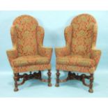 A pair of Continental walnut-framed wing armchairs in the Carolean style, raised on carved legs