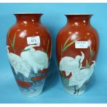 A pair of Japanese porcelain vases decorated with Egrets on a red background, 30cm and a pair of