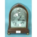 An early-20th century mahogany mantel clock, the lancet-shaped case with arched silvered dial with