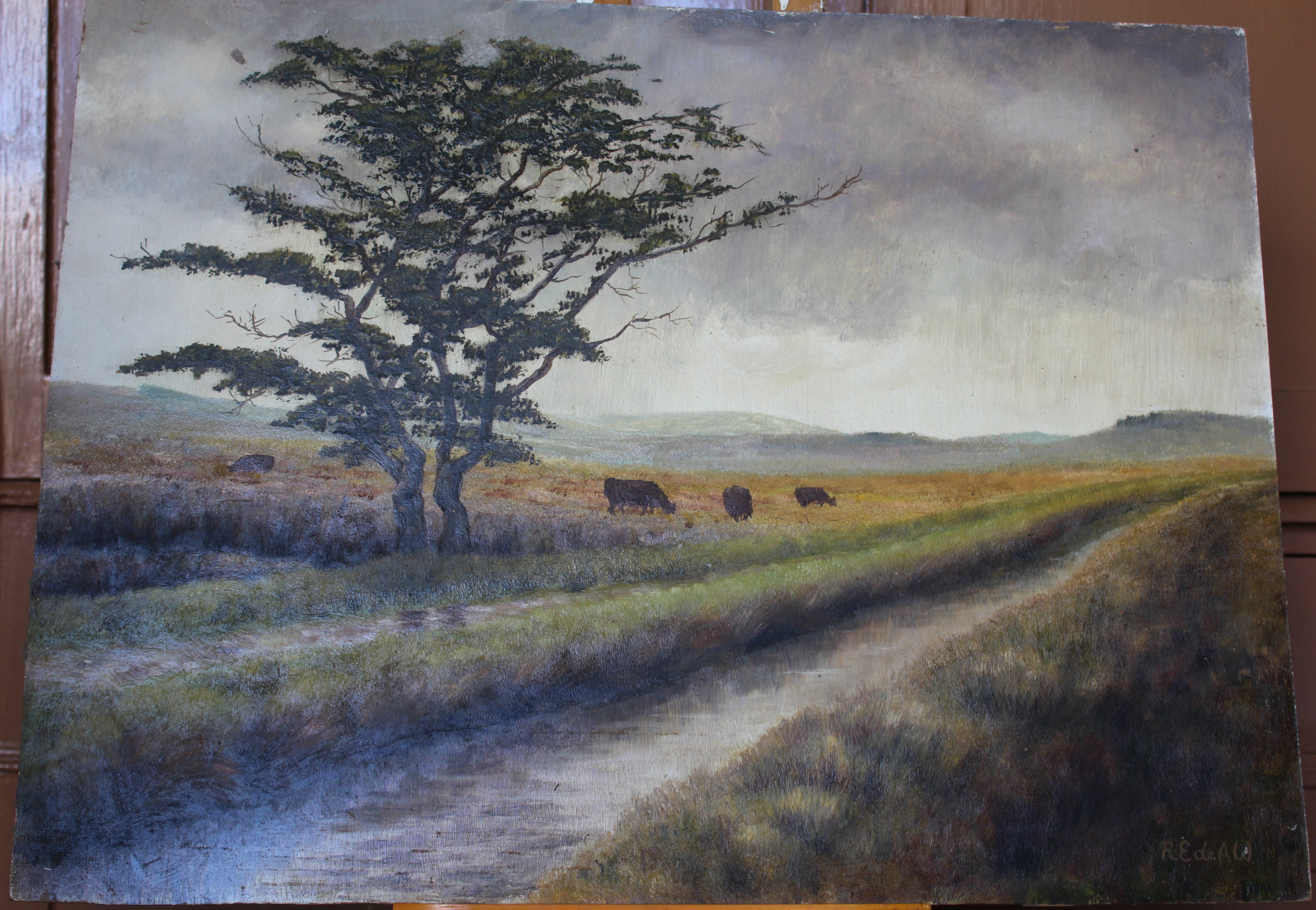 •MOORLAND LANDSCAPE WITH LEAT, TREES AND CATTLE Signed unframed oil on board, 45.5 x 60.5cm.
