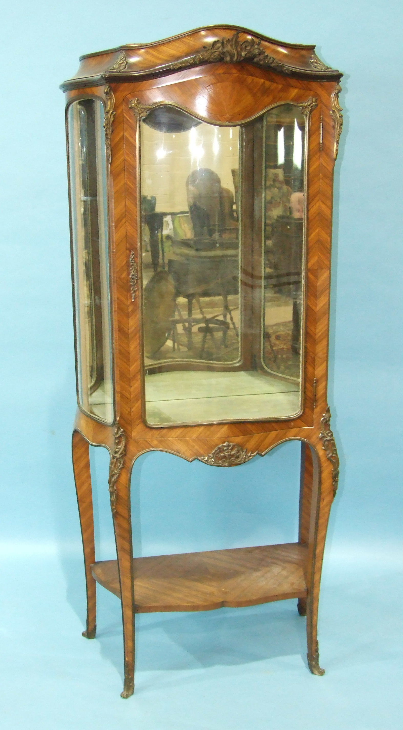 A 19th century kingwood vitrine in the Louis XV taste, with serpentine glazed door and side panels