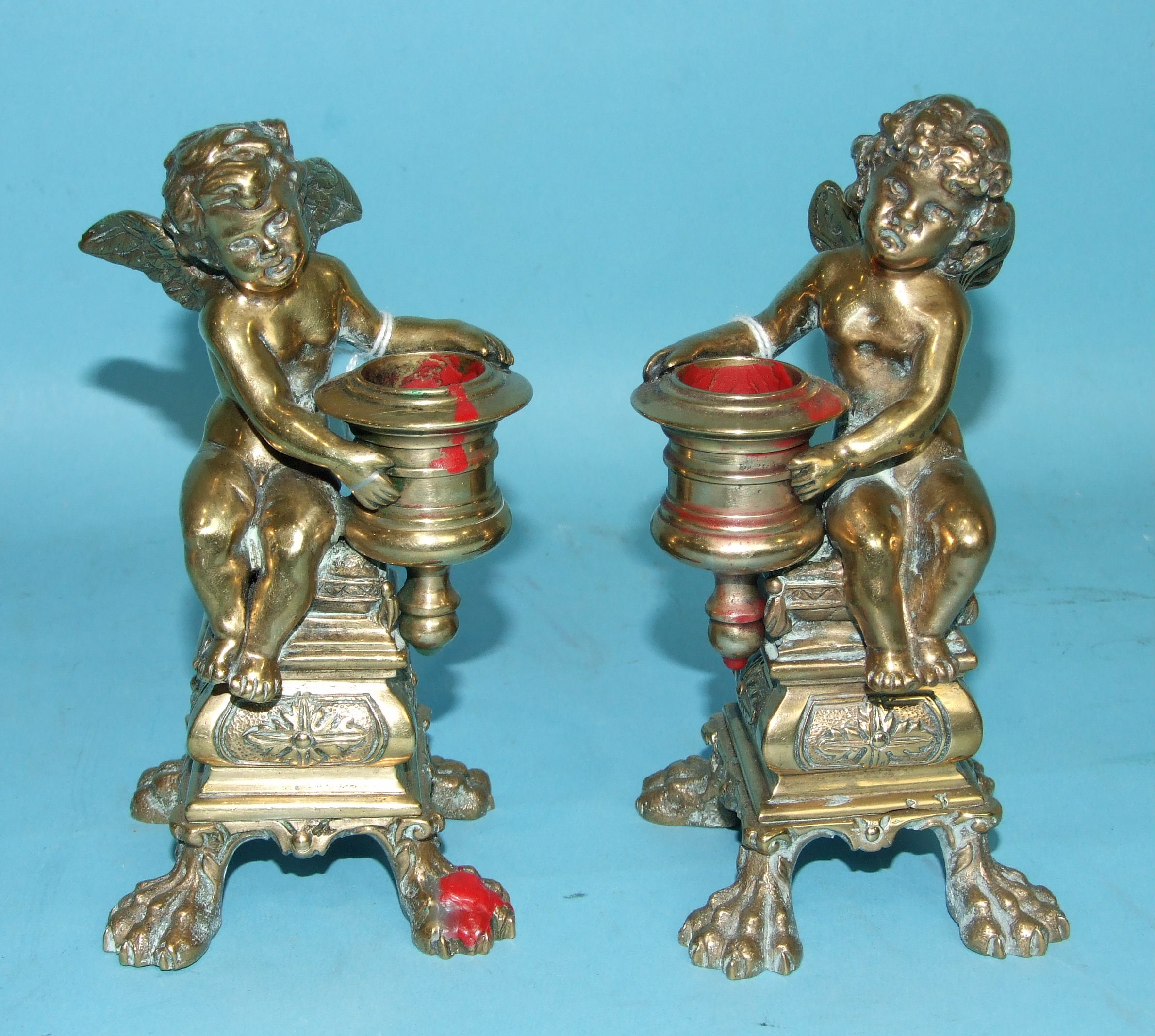 A pair of late-19th century cast bronze candlesticks in the form of winged cherubs, (2).