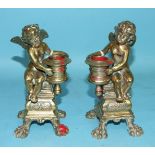 A pair of late-19th century cast bronze candlesticks in the form of winged cherubs, (2).