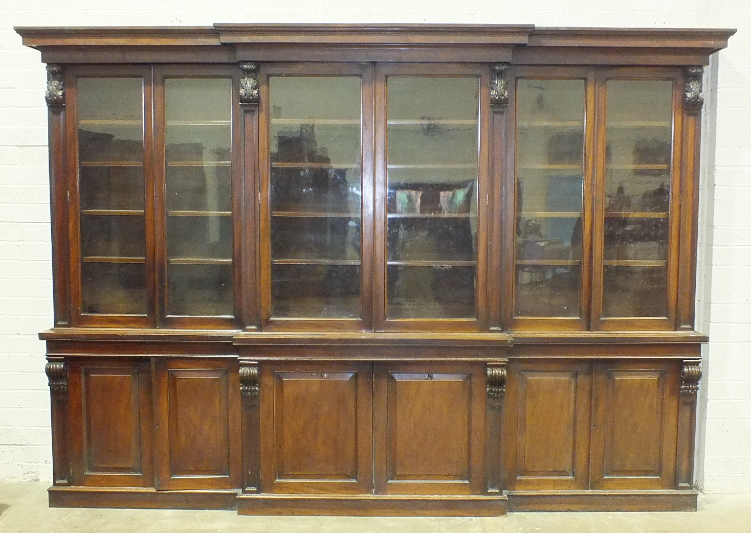 A large Victorian mahogany breakfront bookcase, the moulded stepped cornice supported by carved - Image 2 of 3