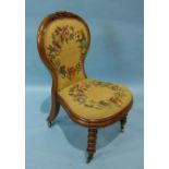 A Victorian carved walnut spoon-back nursing chair on bobbin-turned front legs and an upholstered