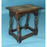 An oak joint stool, the top with moulded edge, on turned legs joined by stretchers, 46cm wide.