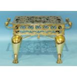 A brass two-handled footman with pierced top, on cabriole legs and paw feet, 54cm wide, 29cm high,