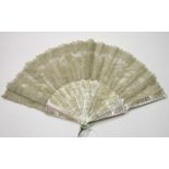 A 19th century mother-of-pearl and lace fan, the guards and sticks pierced and carved with
