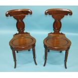 A pair of George IV mahogany hall chairs, each with skeleton back and circular solid seat, on turned