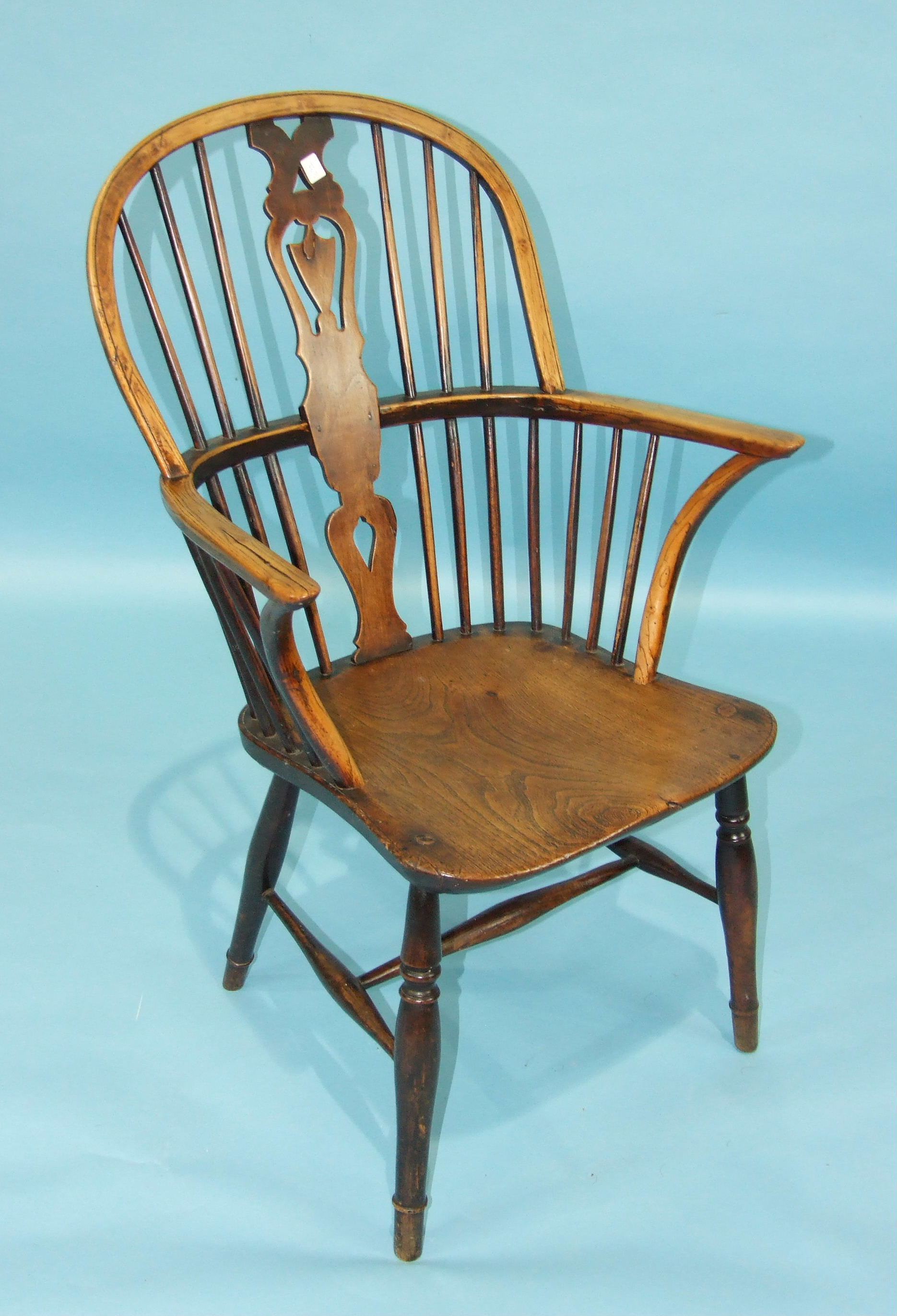 An elm and beech Windsor armchair, the shaped solid seat on turned legs with H-stretcher.