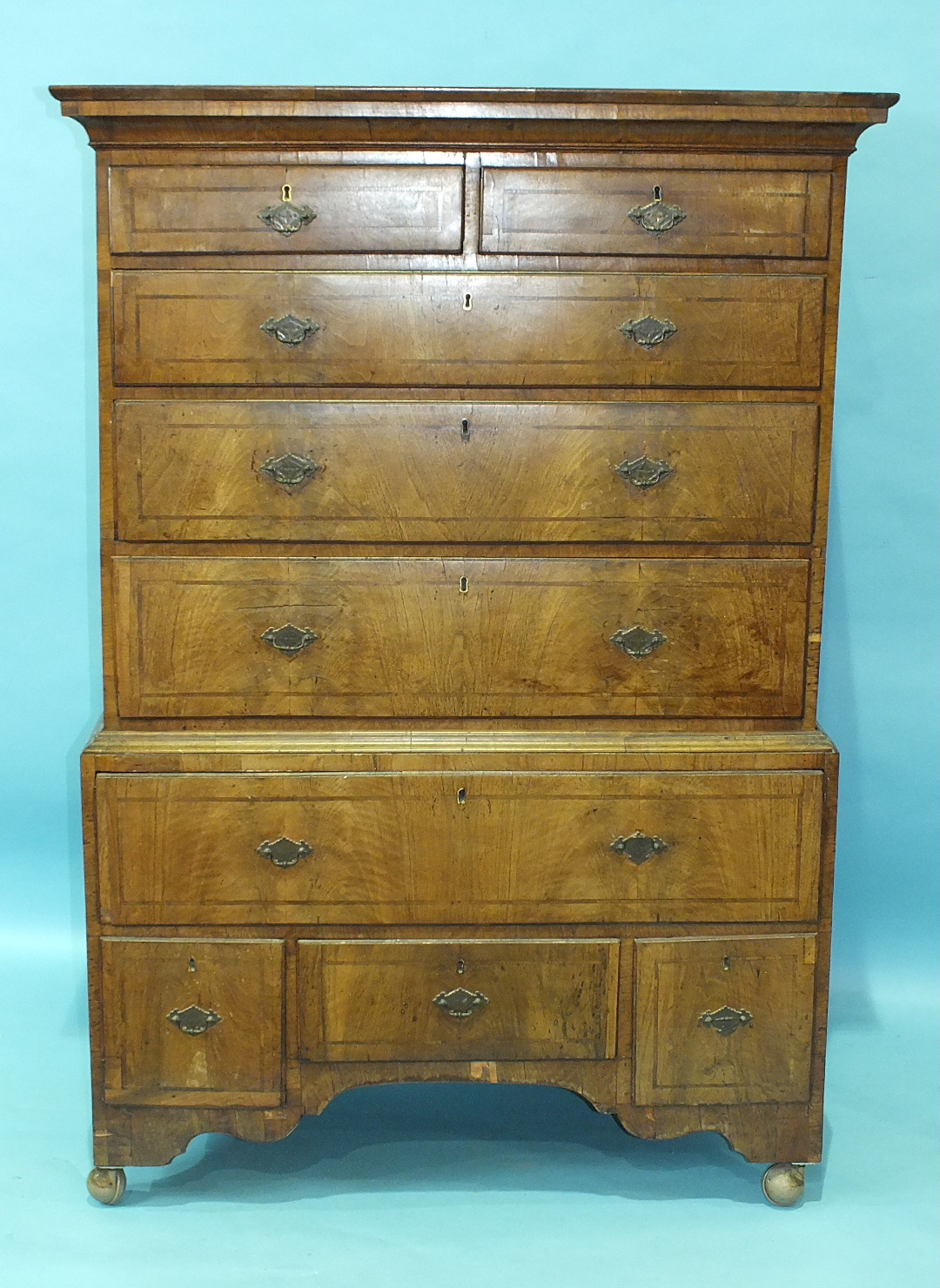 An 18th century walnut chest on stand, the moulded cornice above two short and three long drawers,