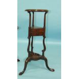 An 18th century mahogany tripod wash stand, the filled bowl aperture and two small drawers supported