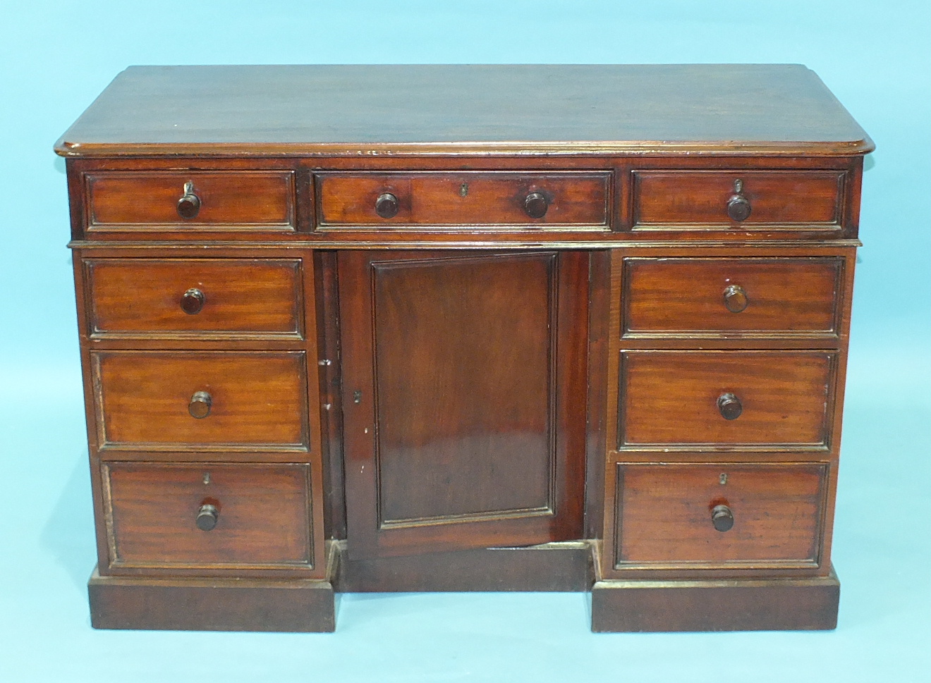 A Late-Victorian mahogany knee-hole dressing table having an arrangement of three frieze drawers and