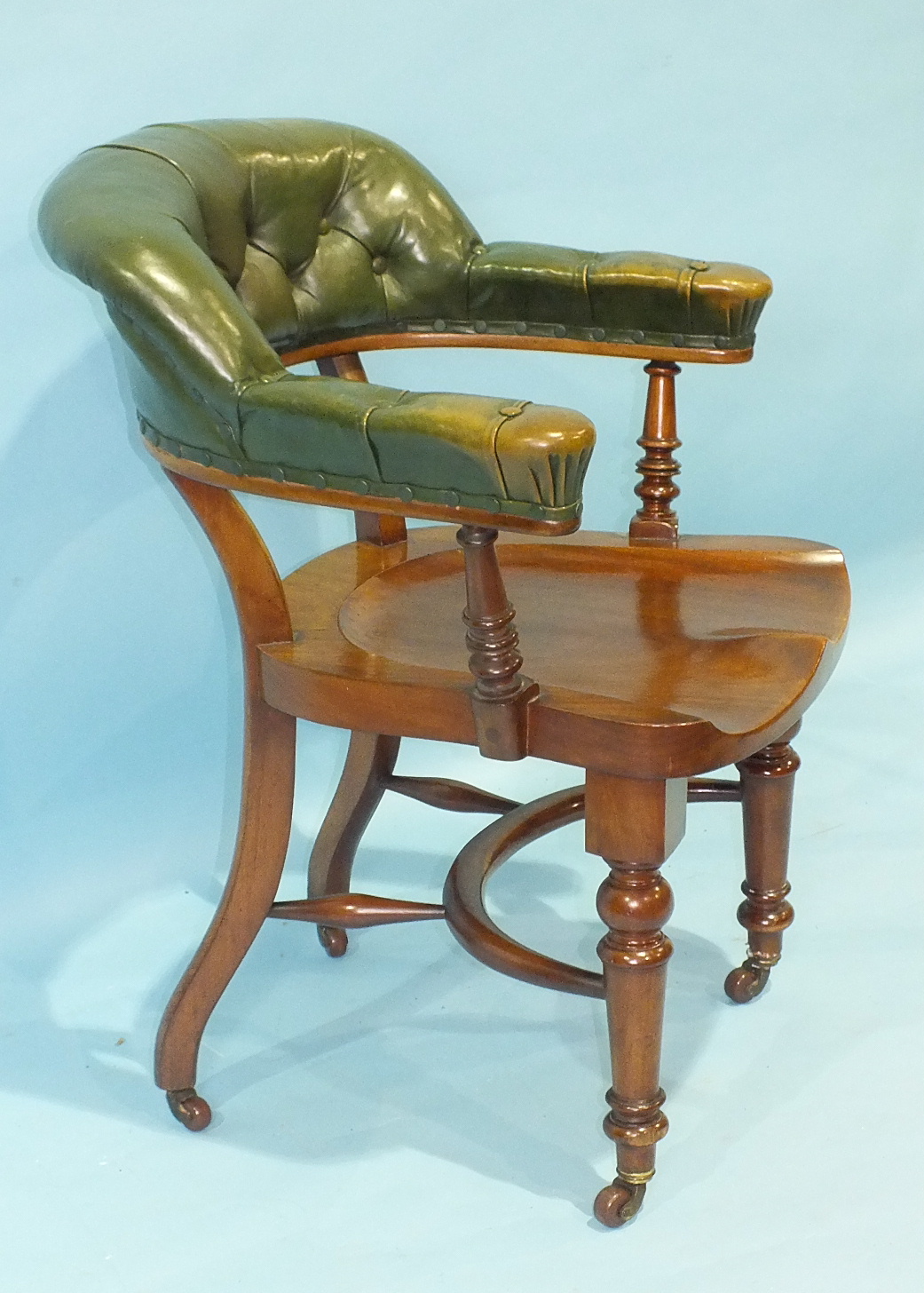 A late-19th century mahogany library chair, the partially-upholstered leather button back and arms