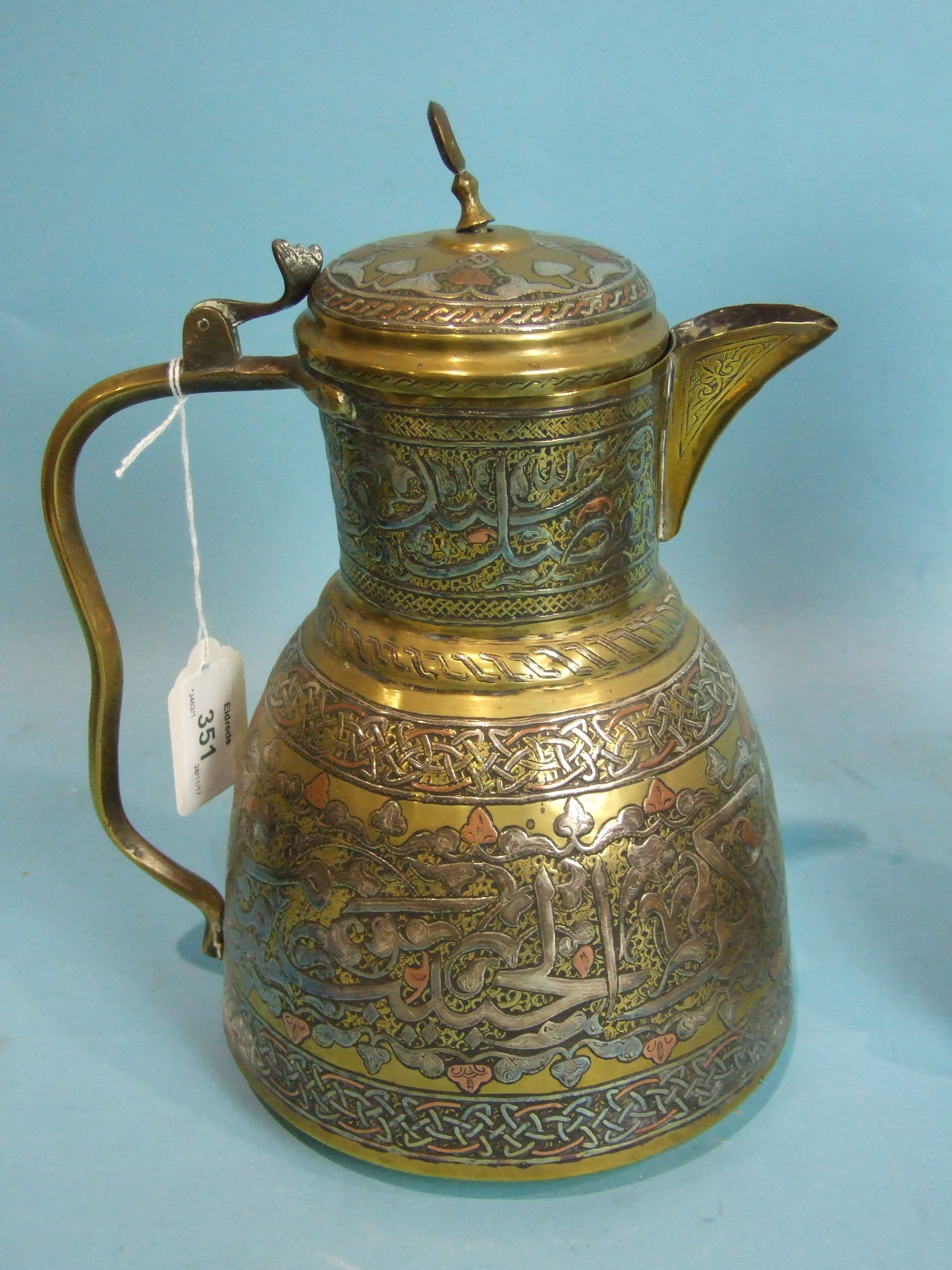 A Middle Eastern brass ewer inlaid with silver and copper, two similar smaller pieces and a stone - Image 3 of 4