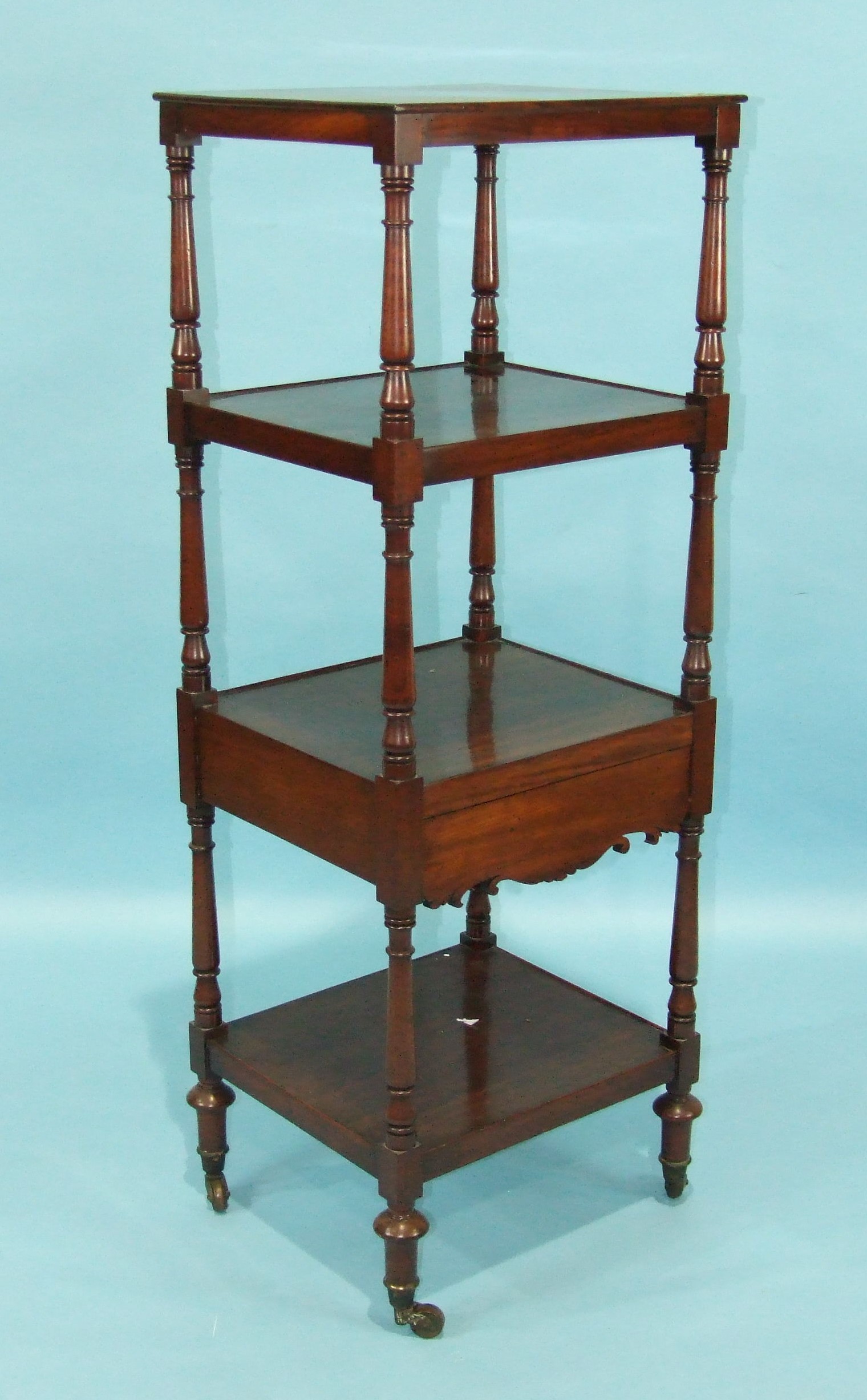 An early-19th century mahogany four-tier watnot, the tiers and frieze drawer separated by turned