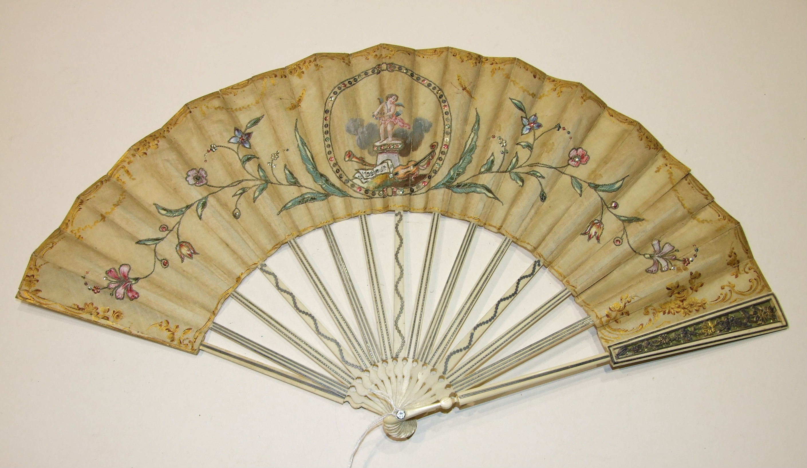 An 18th century fan, the guards pierced and overlaid with gold and silver, the sticks inlaid with