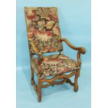 An antique Continental chestnut armchair with upholstered back and seat, serpentine arms and