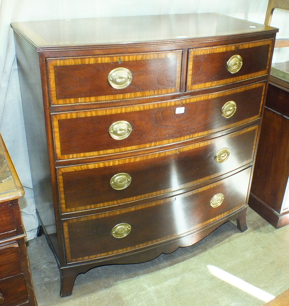 A Georgian mahogany and satinwood-banded bow-fronted chest of two short and three long drawers, on