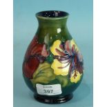 A Moorcroft Pottery vase decorated in the Hibiscus design, on a green and blue ground, impressed