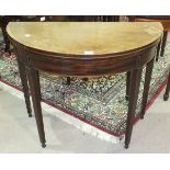 A Georgian inlaid cross-banded mahogany fold-over tea table, the circular fold-over top on square