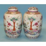 A pair of 19th century Chinese famille rose ovoid jars and covers painted with vases of colourful