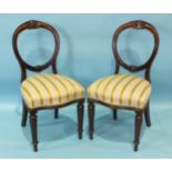 Four Victorian mahogany balloon-back dining chairs, the open carved backs and upholstered serpentine
