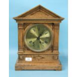 An oak mantel clock of architectural form, with brass dial and gong-striking movement stamped 'W & H