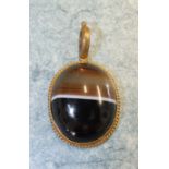 An onyx agate pendant with gilt metal mounts, 3.7 x 3cm.