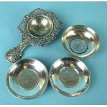 A Continental white metal tea strainer with pierced foliate border and handle, 14cm long and three