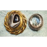 A large Victorian brooch set banded agate cabochon in gilt metal swivel mount with glazed locket