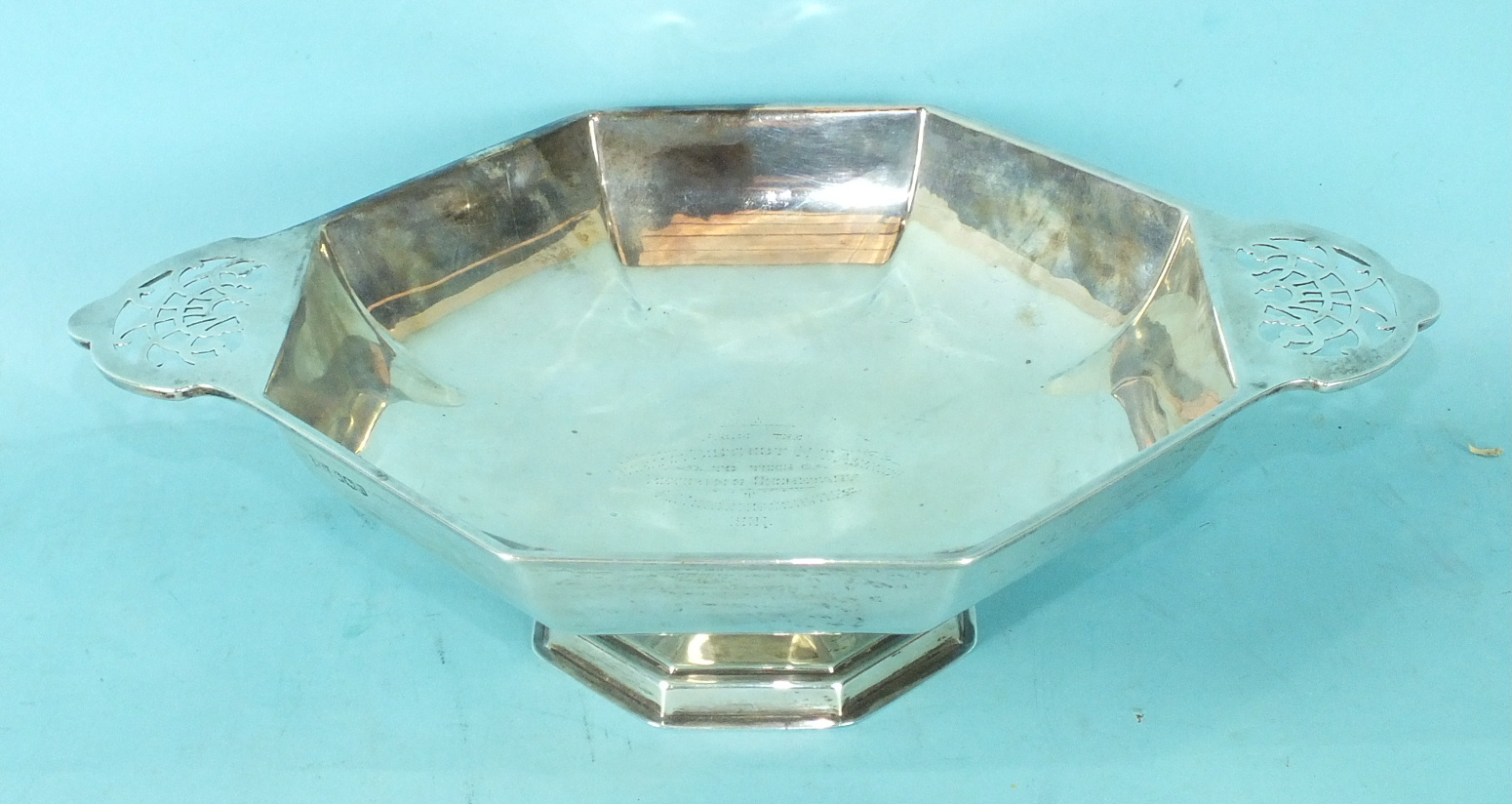 An octagonal silver fruit dish, two sides extended and pierced to form handles, by Walker & Hall,