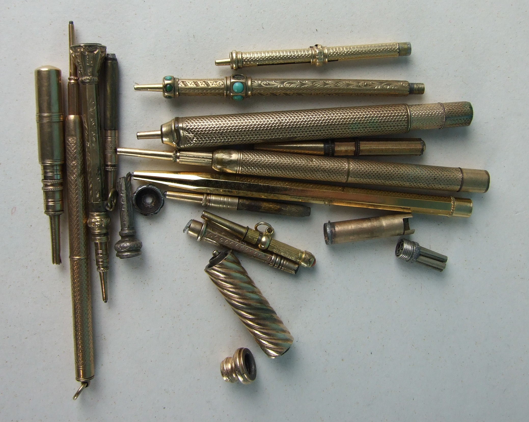 A collection of nine gilt metal propelling pencils (some af), and other similar items.